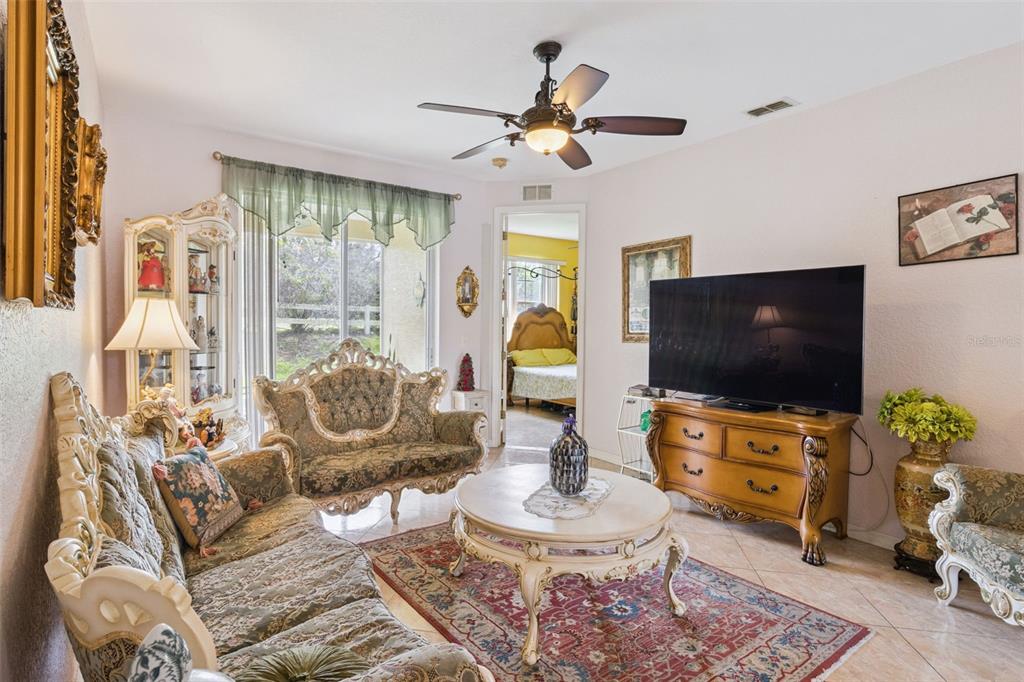 A living room features ornate traditional furniture, a large television, a ceiling fan, and tile flooring — 5101 LAKE MARION GOLF RESORT UNIT 5101, KISSIMMEE, FL