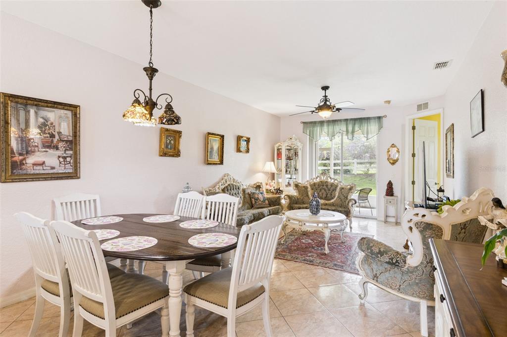 A dining area and living room with tile floors, ornate furniture, and a sliding glass door — 5101 LAKE MARION GOLF RESORT UNIT 5101, KISSIMMEE, FL