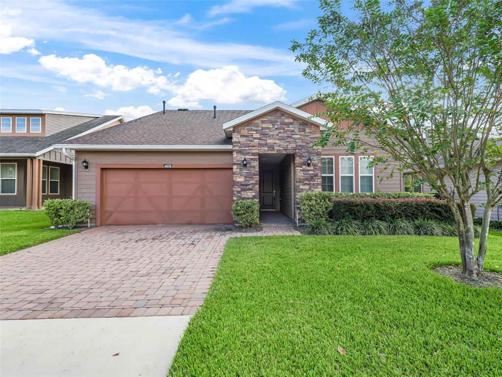 A single-story house features a stone facade, a brown garage door, and a brick driveway — 4976 NW 35TH LANE ROAD, OCALA, FL