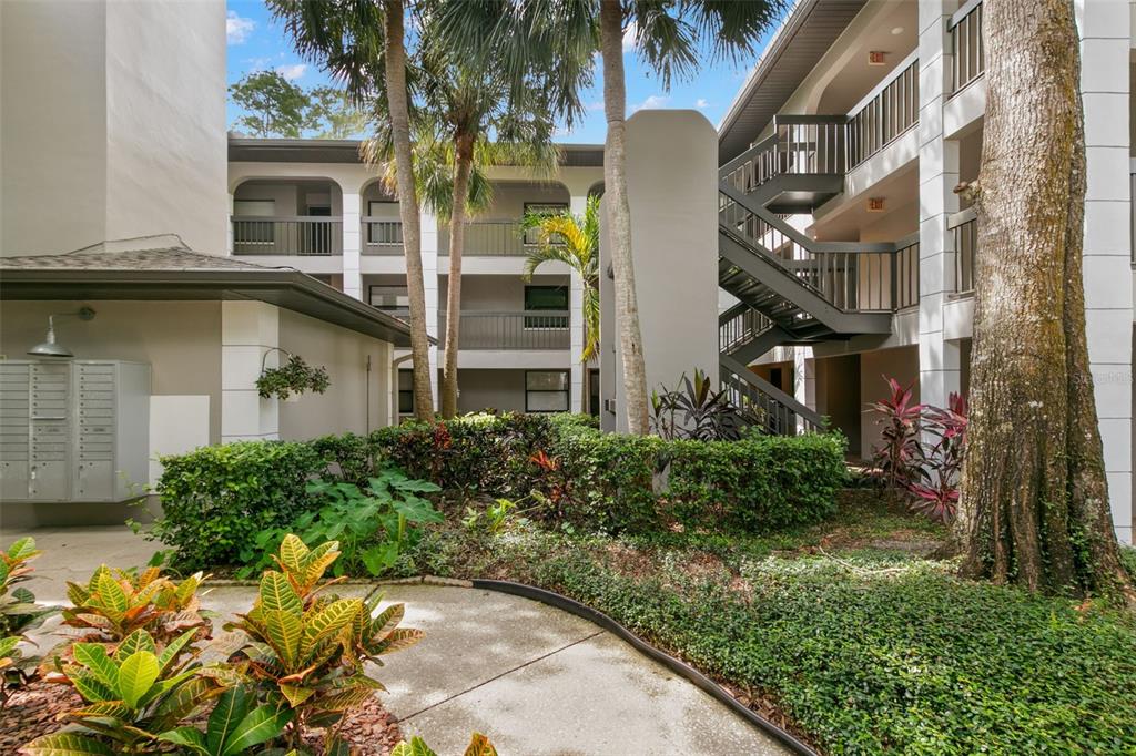An exterior view of a multi-story apartment building with a staircase and a mail kiosk — 3399 MERMOOR DRIVE UNIT 309, PALM HARBOR, FL