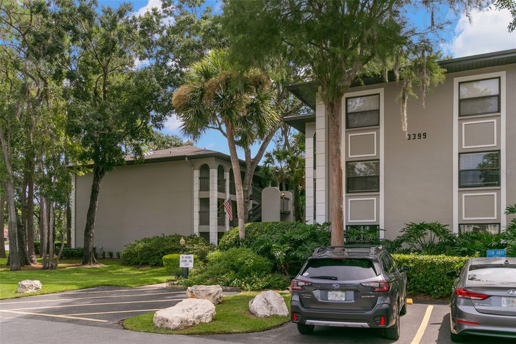 A multi-story apartment building with a parking lot and landscaping in front — 3399 MERMOOR DRIVE UNIT 309, PALM HARBOR, FL