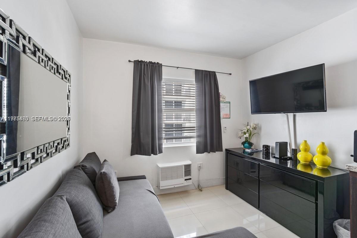 A small living room features a grey sofa, a wall-mounted television, and tile flooring — 335 Ocean Dr # 310, Miami Beach FL 33139, MIAMI BEACH, FL