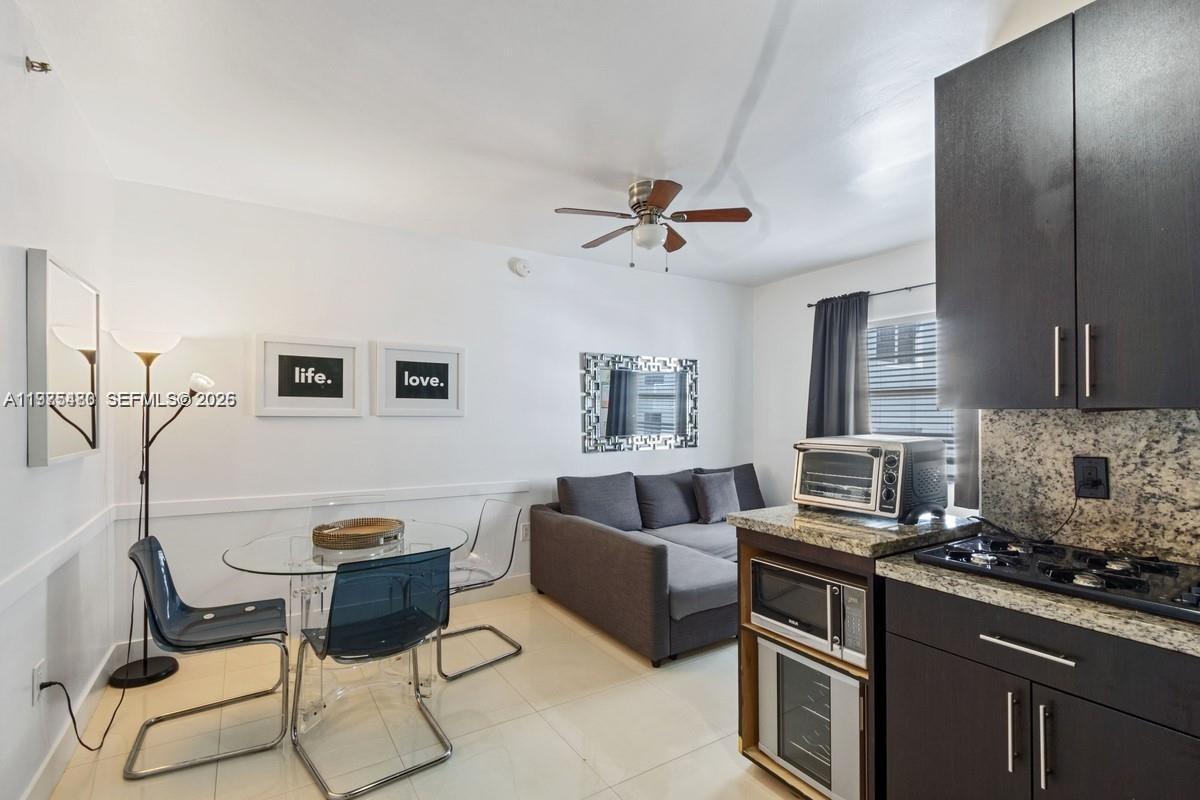 A small living and dining area features a glass table, gray sofa, and dark cabinetry — 335 Ocean Dr # 310, Miami Beach FL 33139, MIAMI BEACH, FL