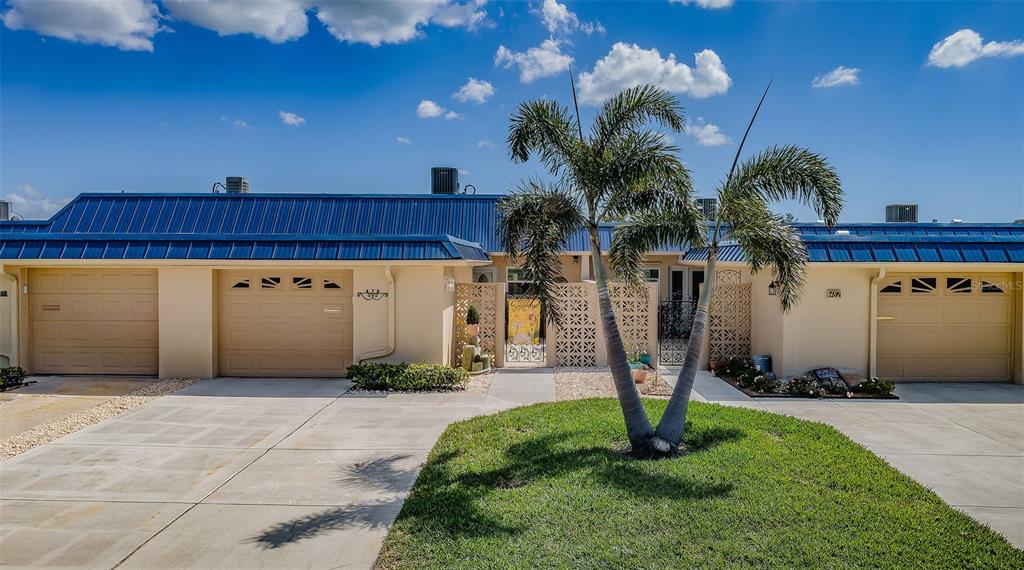 An aerial view shows a row of waterfront townhomes with blue metal roofs — 476 BOCA CIEGA POINT BOULEVARD S, ST PETERSBURG, FL