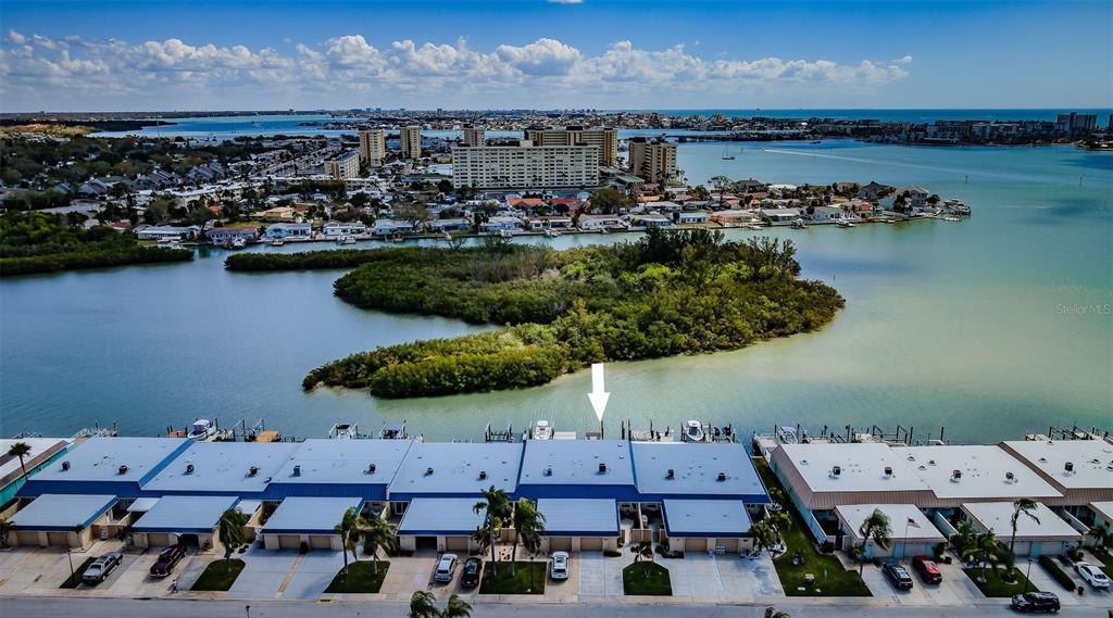 A single-story residential building features a blue metal roof, three garage doors, and a palm tree — 476 BOCA CIEGA POINT BOULEVARD S, ST PETERSBURG, FL