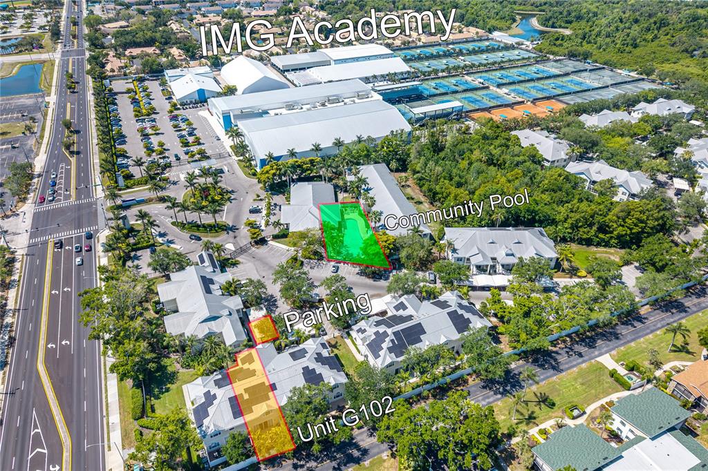 This aerial view shows a residential complex with a pool, parking, and nearby sports facilities — 3405 54TH DRIVE W UNIT 102, BRADENTON, FL