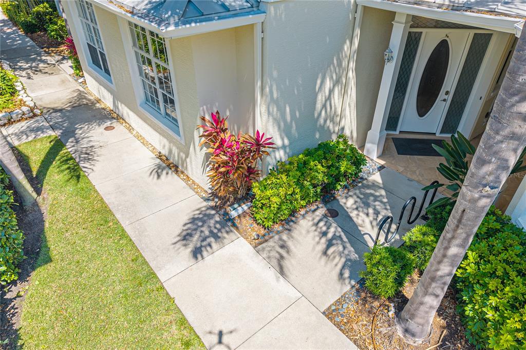 An elevated view of a house exterior featuring a concrete walkway leading to the front door — 3405 54TH DRIVE W UNIT 102, BRADENTON, FL