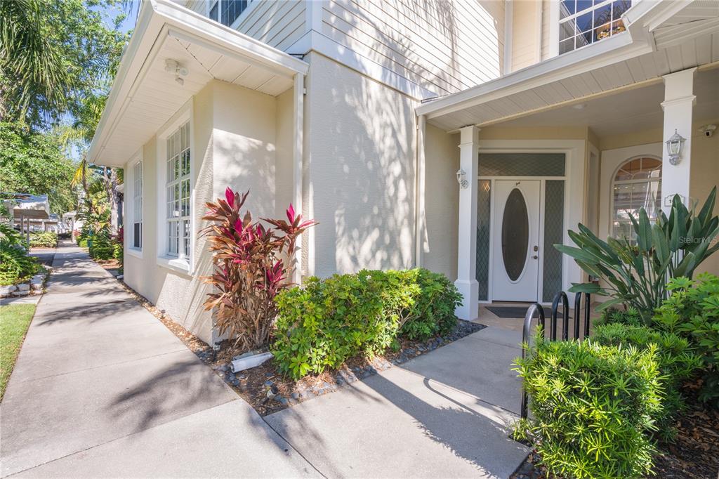 A sidewalk leads to the front entrance of a two-story house with light-colored siding — 3405 54TH DRIVE W UNIT 102, BRADENTON, FL