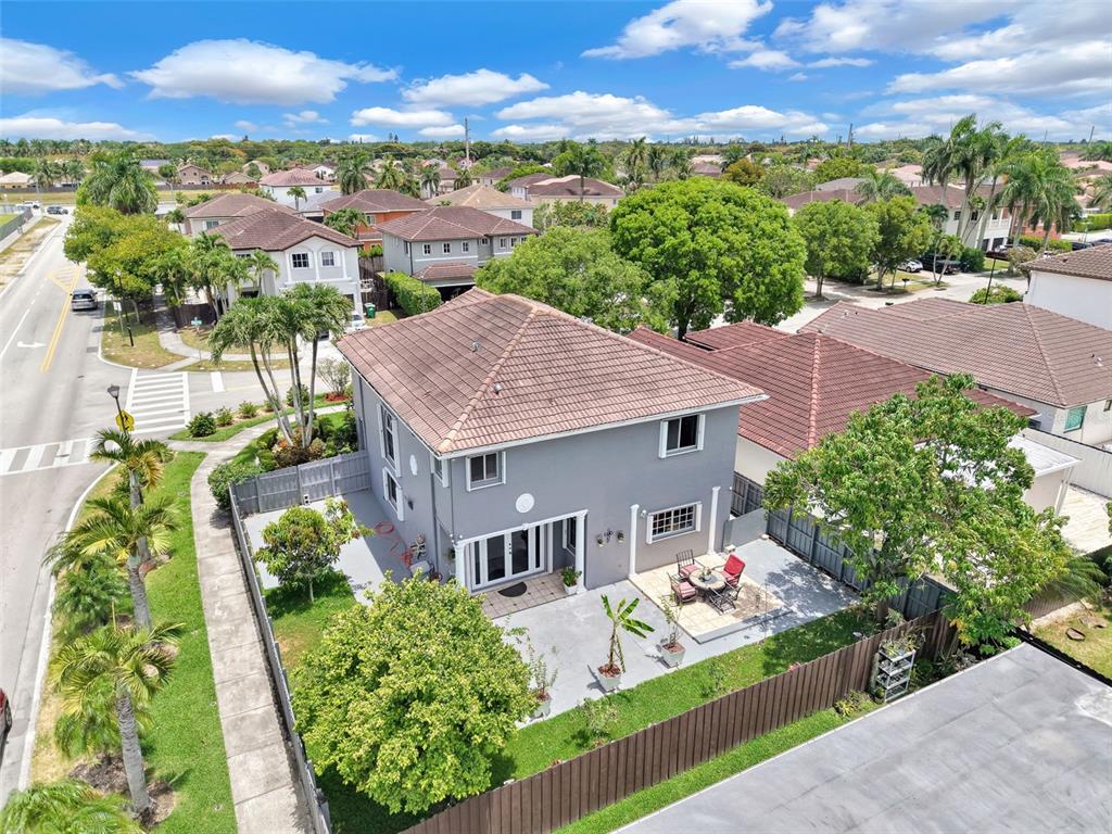 An aerial view shows a two-story gray house with a tiled roof and backyard patio — 14402 SW 157TH PATH, MIAMI, FL