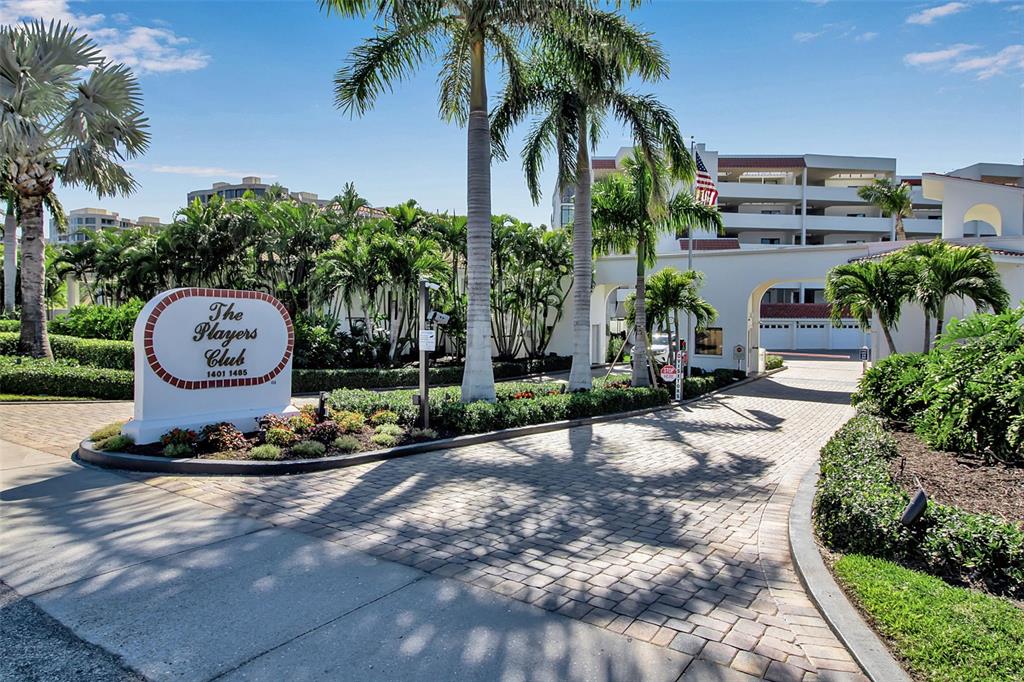 The entrance to a residential complex features a sign, palm trees, and a paved driveway — 1485 GULF OF MEXICO DRIVE UNIT 303, LONGBOAT KEY, FL