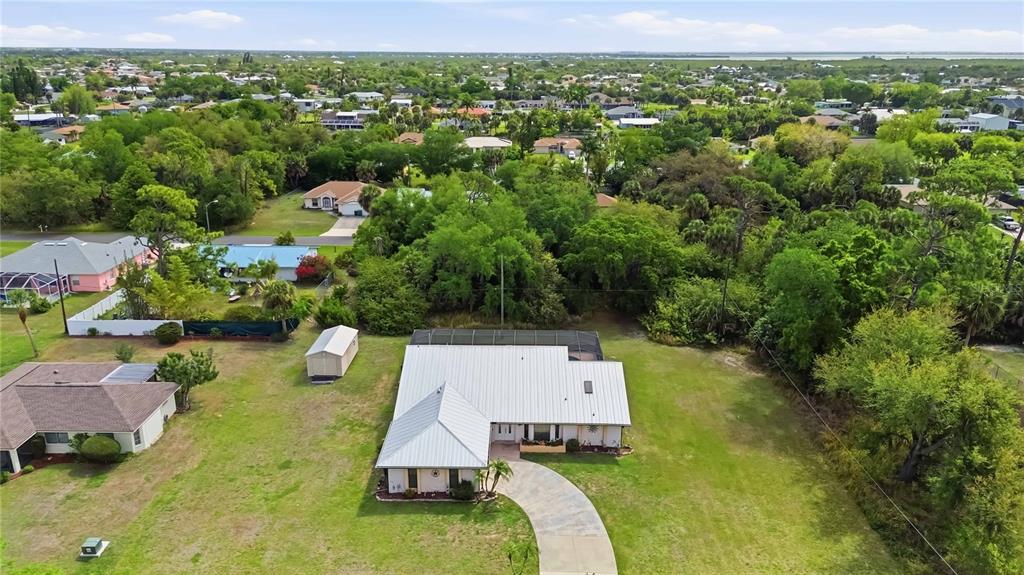 An aerial view shows a single-story house with a metal roof and a paved driveway — 4346 MELIS STREET, PORT CHARLOTTE, FL