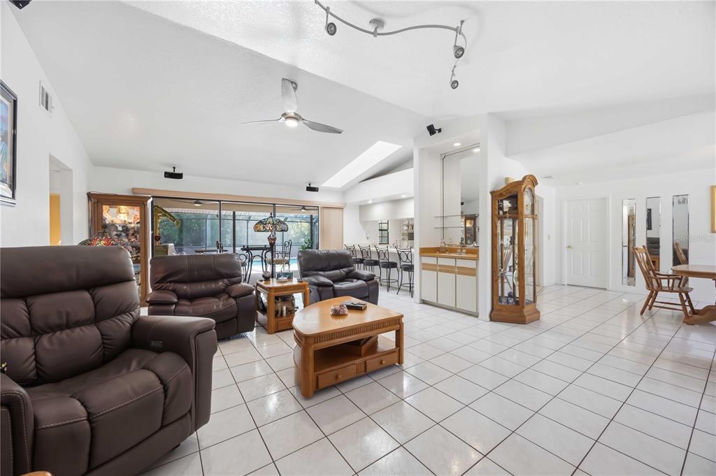 A spacious living room with white tile floors, brown leather furniture, and a wet bar — 4346 MELIS STREET, PORT CHARLOTTE, FL