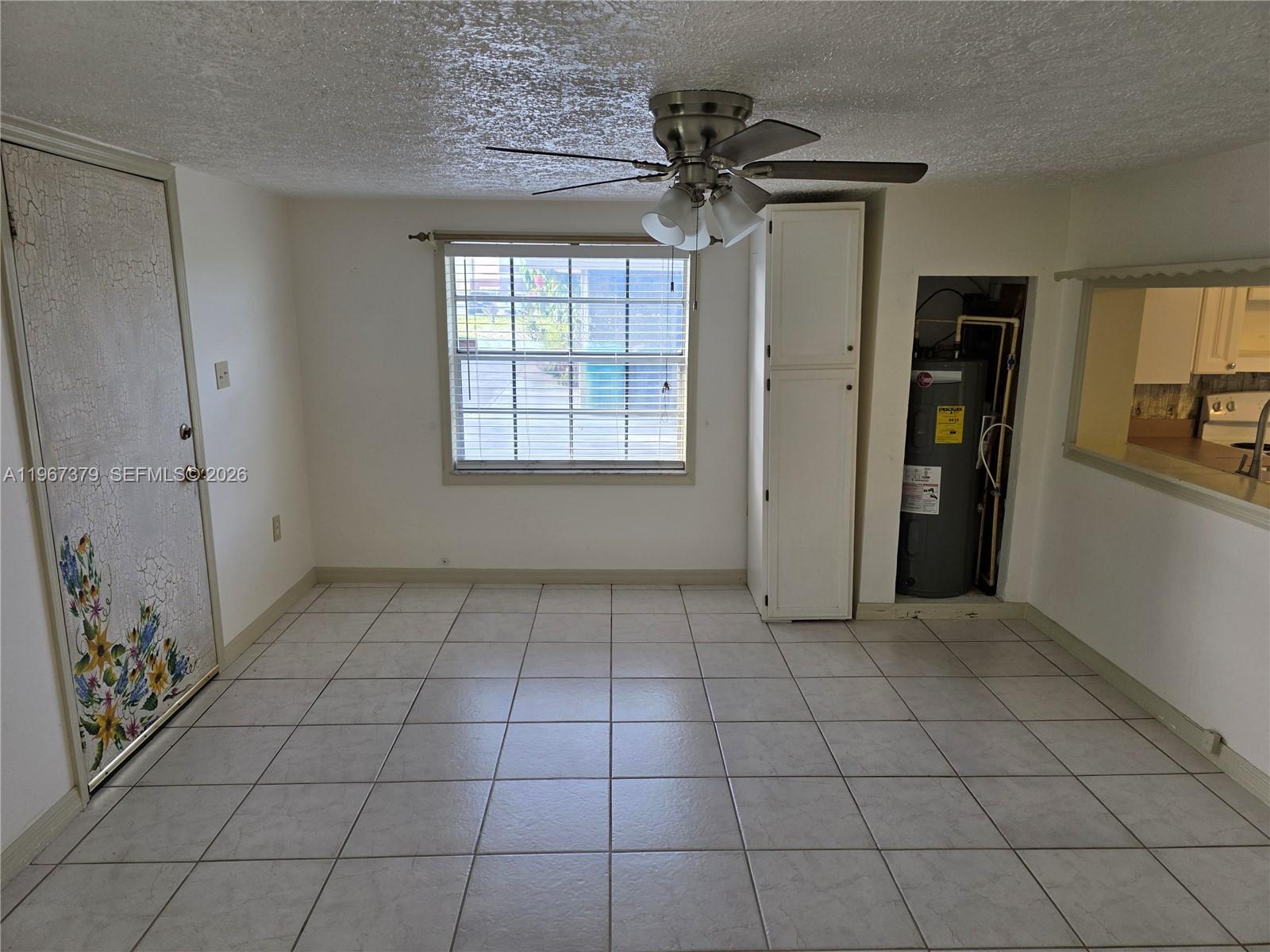A dining area features tile flooring, a ceiling fan, a window, and a water heater closet — 4321 Kirby Loop Rd # 2, Fort Pierce FL 34981, FORT PIERCE, FL