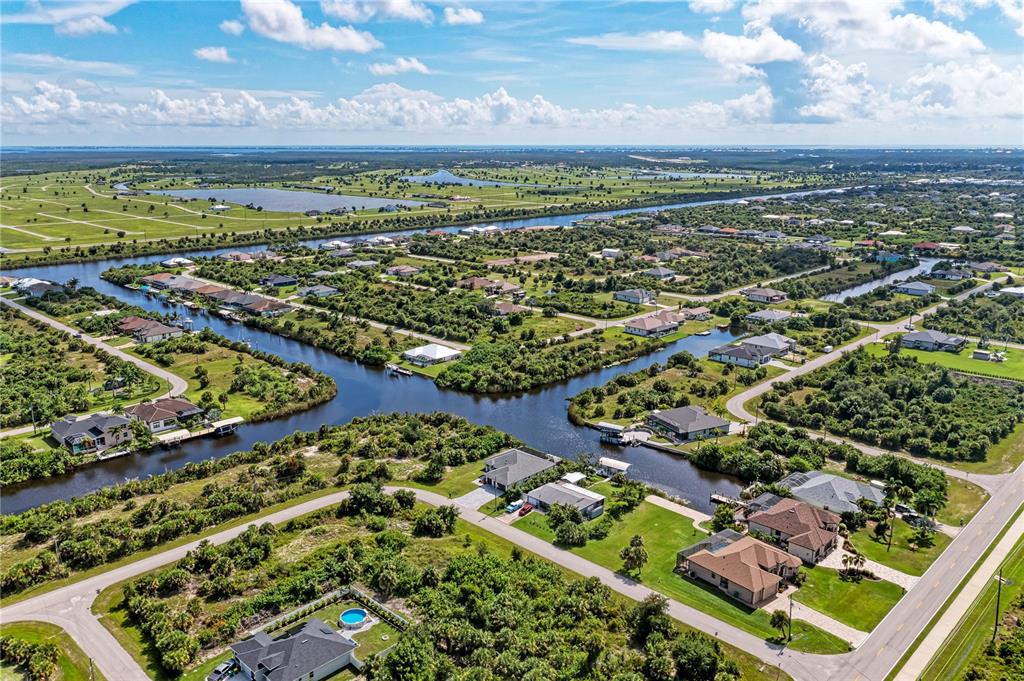 An aerial view shows houses situated along a network of canals in a suburban area — 10442 MCALESTER CIRCLE, PORT CHARLOTTE, FL