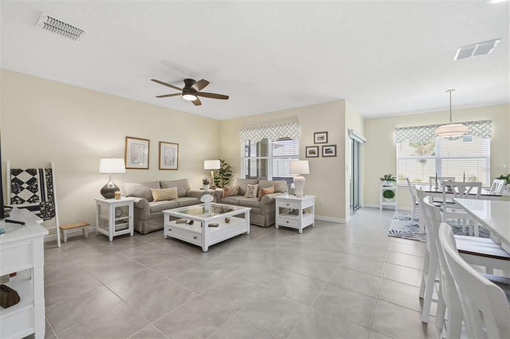 A bright open-concept living and dining area with light tile flooring and neutral walls — 33731 HAMILTON HILL LANE, WESLEY CHAPEL, FL