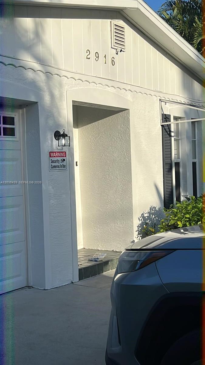 A white exterior wall features the house number 2916, a security sign, and a doorway — 2916 12th Ave, Vero Beach FL 32960, VERO BEACH, FL
