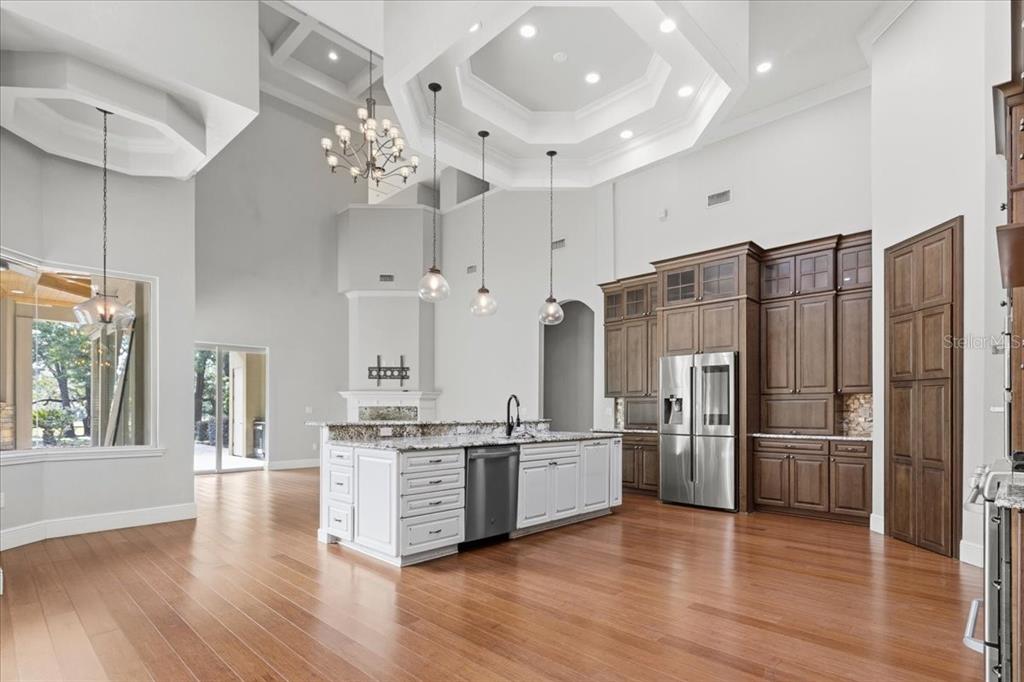 A kitchen with a white island, stainless steel appliances, and dark wood cabinetry — 7369 NW 187TH TERRACE, ALACHUA, FL