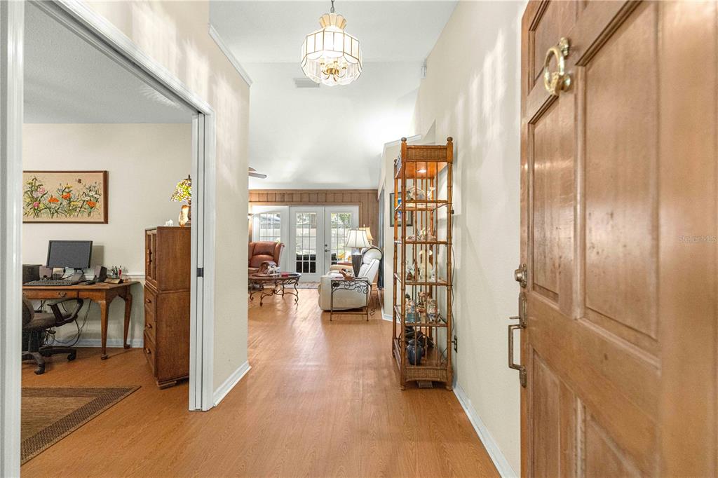 A view from an entryway looking into a living room with wood-look flooring — 3644 SE 22ND AVENUE, OCALA, FL