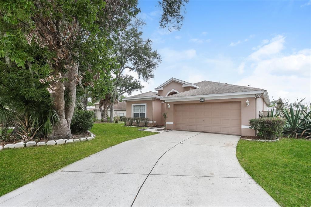 A single-story house with a beige exterior, a two-car garage, and a concrete driveway — 814 COADE STONE DRIVE, SEFFNER, FL