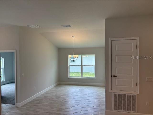 A dining area features light-colored tile flooring, a chandelier, and a white door — 7673 SW 180TH CIRCLE, DUNNELLON, FL