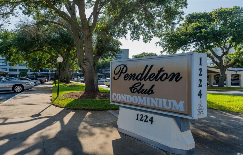 A sign for the Pendleton Club Condominium stands on a sidewalk near a parking lot — 1224 S PENINSULA DRIVE UNIT 304, DAYTONA BEACH, FL