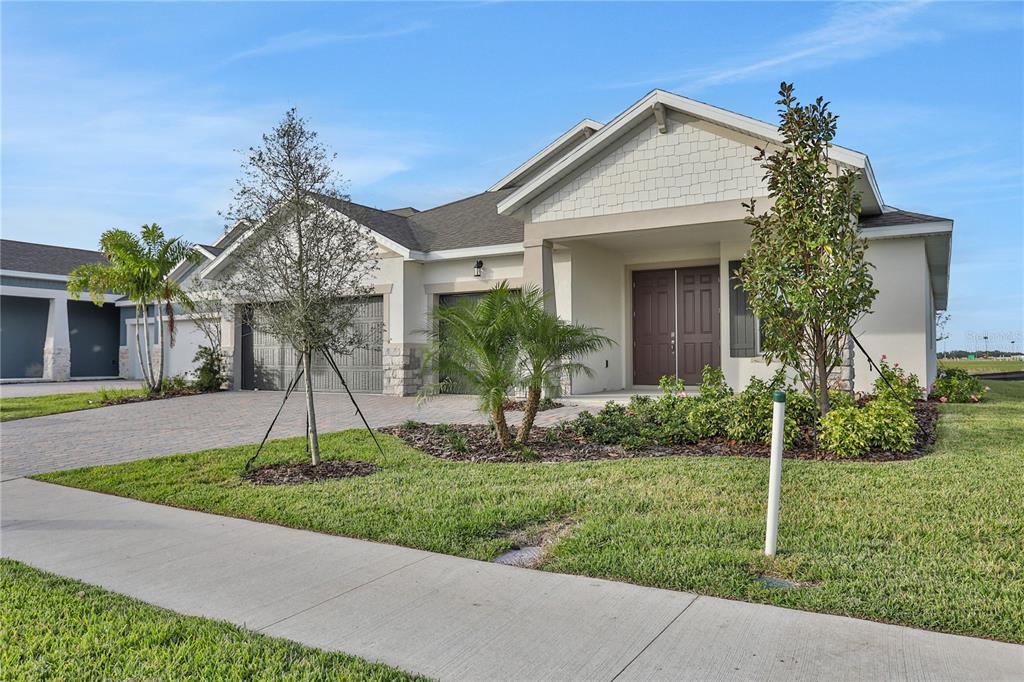 A single-story house with a paved driveway, two garage doors, and a covered front entrance — 7413 SEA MANATEE STREET, PARRISH, FL