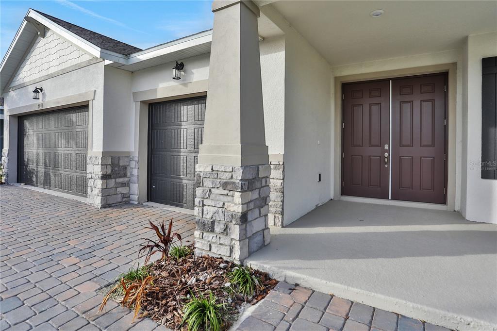 A house exterior features a double garage, a stone-accented pillar, and a double front door — 7413 SEA MANATEE STREET, PARRISH, FL
