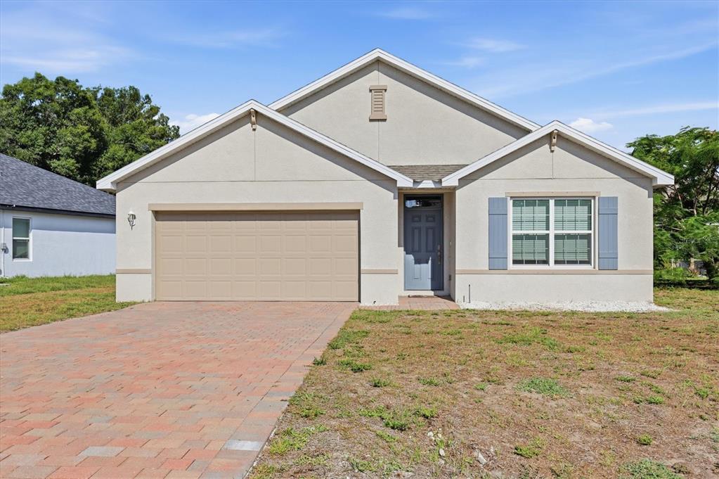 A single-story house with a beige stucco exterior, a two-car garage, and a paved driveway — 258 RIO DE JANEIRO AVENUE, PUNTA GORDA, FL