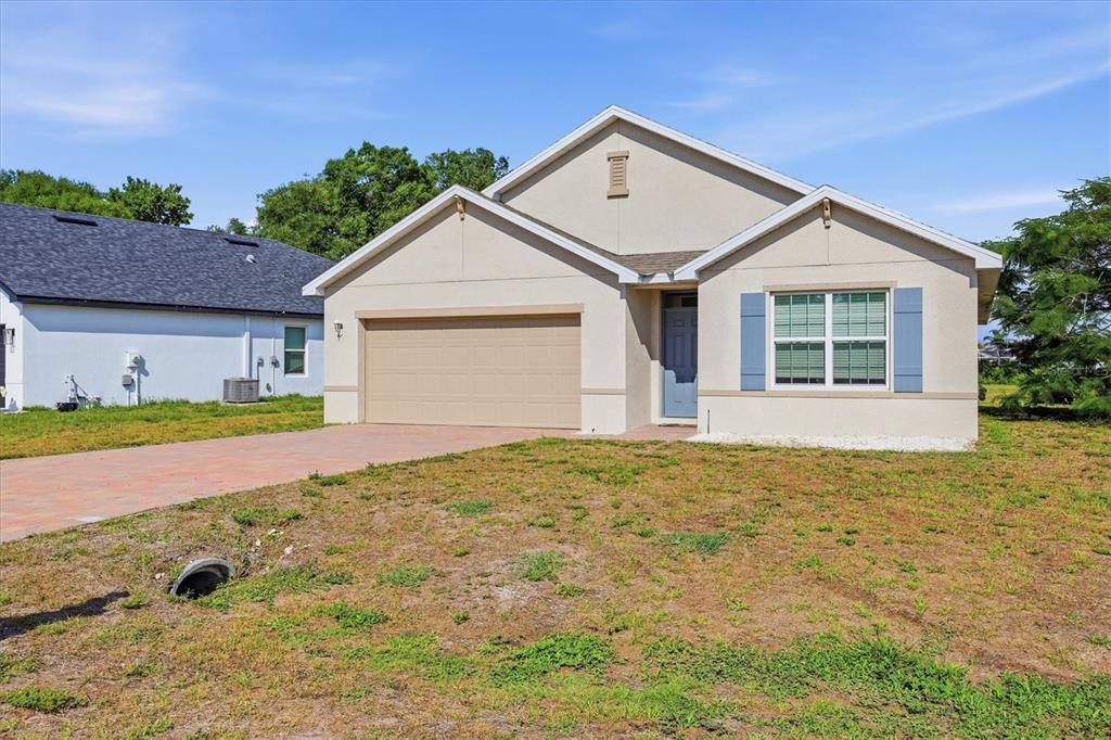 A beige single-story house with a two-car garage and a paved driveway — 258 RIO DE JANEIRO AVENUE, PUNTA GORDA, FL