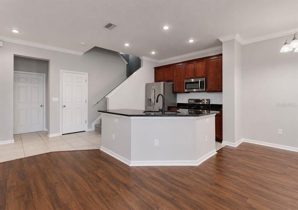 A kitchen with dark wood cabinets, stainless steel appliances, and a central island — 7539 TAMARIND AVENUE, TAMPA, FL