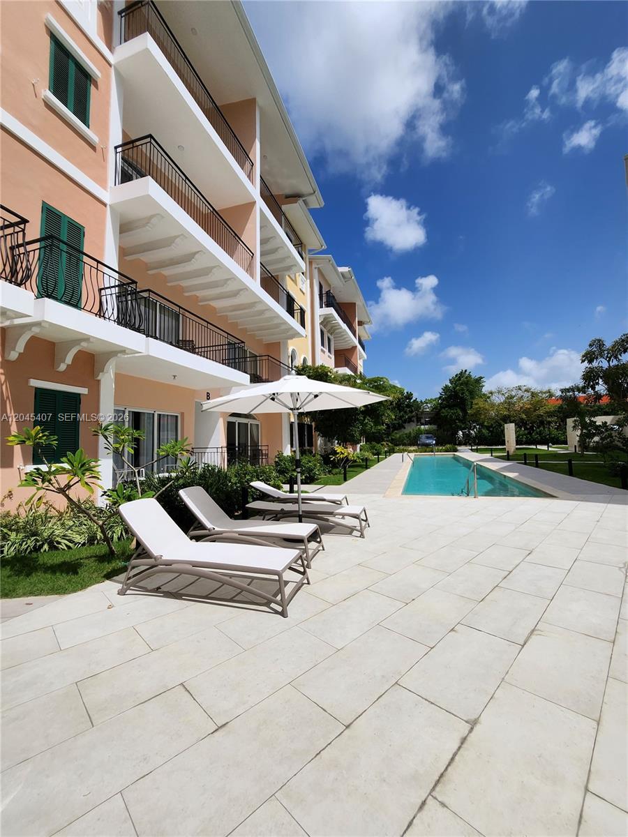 A multi-story apartment building overlooks a swimming pool with lounge chairs on a patio — D.R. AVENIDA ALEMANIA # 2, DR, DR