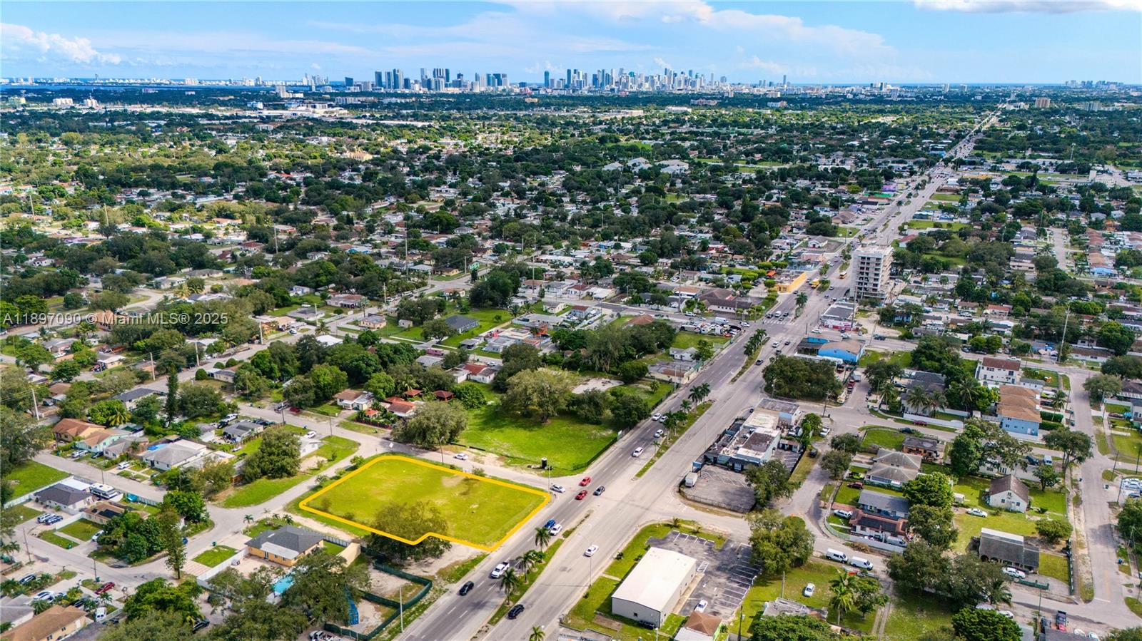 An aerial view shows a vacant, rectangular grass lot highlighted in yellow near a road — 8901 NW 22nd Ave, Miami FL 33147, MIAMI, FL