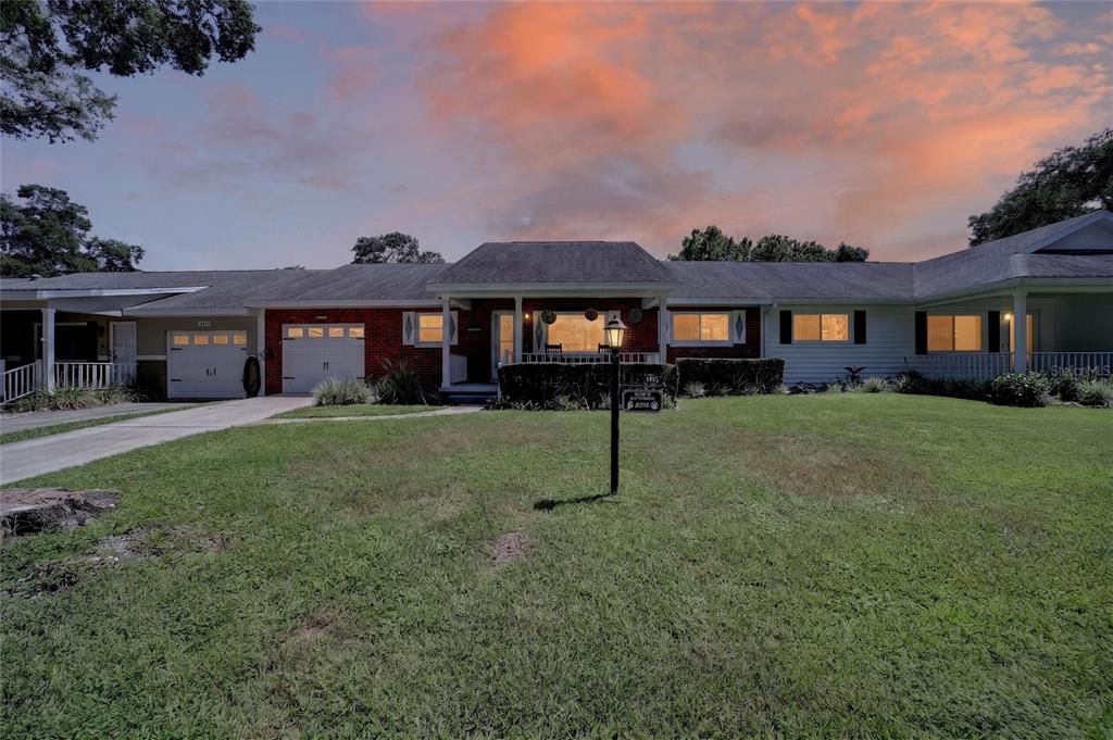 A single-story ranch-style house with a brick facade, attached garage, and a large front lawn — 8674 SW 96TH STREET UNIT D, OCALA, FL
