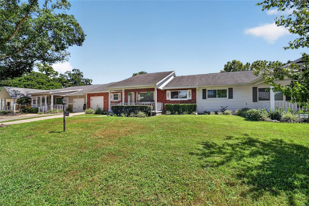 A single-story house with a brick and white siding exterior and a large front lawn — 8674 SW 96TH STREET UNIT D, OCALA, FL