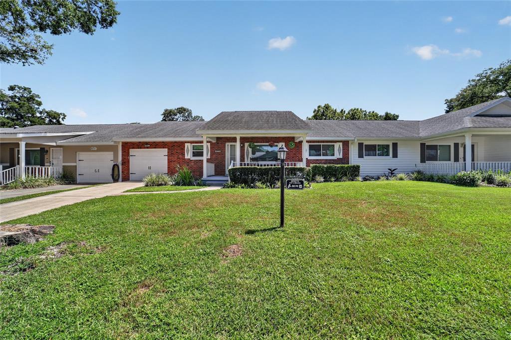 A single-story house with a brick facade, two garage doors, and a large front lawn — 8674 SW 96TH STREET UNIT D, OCALA, FL