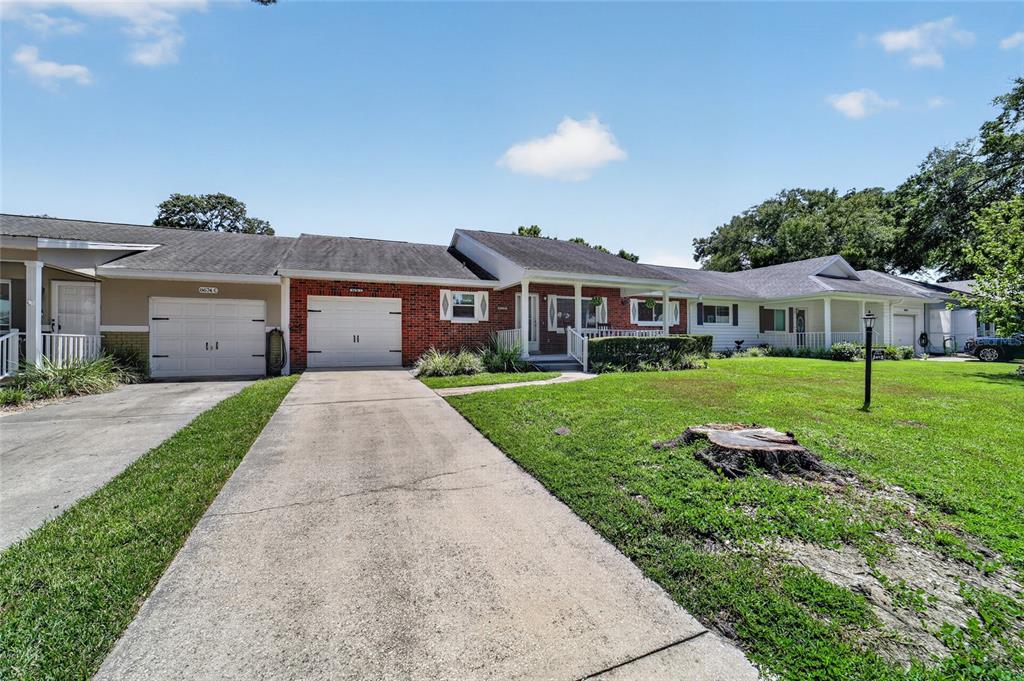 A single-story house with a brick facade, two garage doors, and a concrete driveway — 8674 SW 96TH STREET UNIT D, OCALA, FL