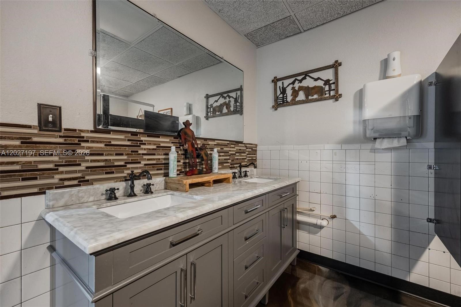 A bathroom features a gray double vanity with a marble countertop and tiled walls — 93 S Hall ST, La Belle FL 33935, LA BELLE, FL