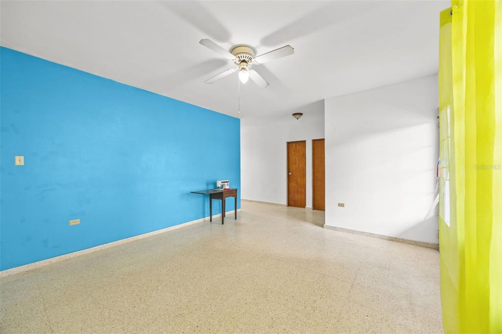 An interior room features a bright blue accent wall, white walls, and light-colored tile flooring — Bo Cruces BO CRUCES, RINCON, PR
