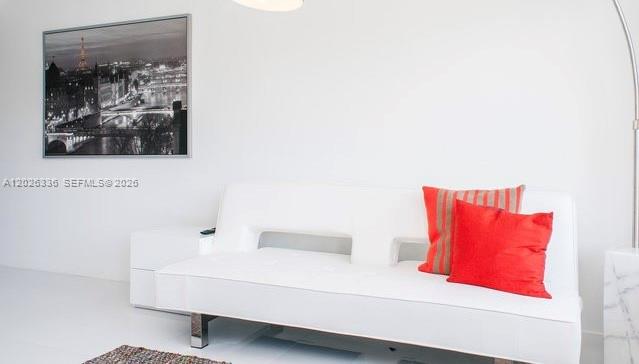 A white sofa with red pillows sits in a room with a framed Paris print — 801 15th St # 208, Miami Beach FL 33139, MIAMI BEACH, FL