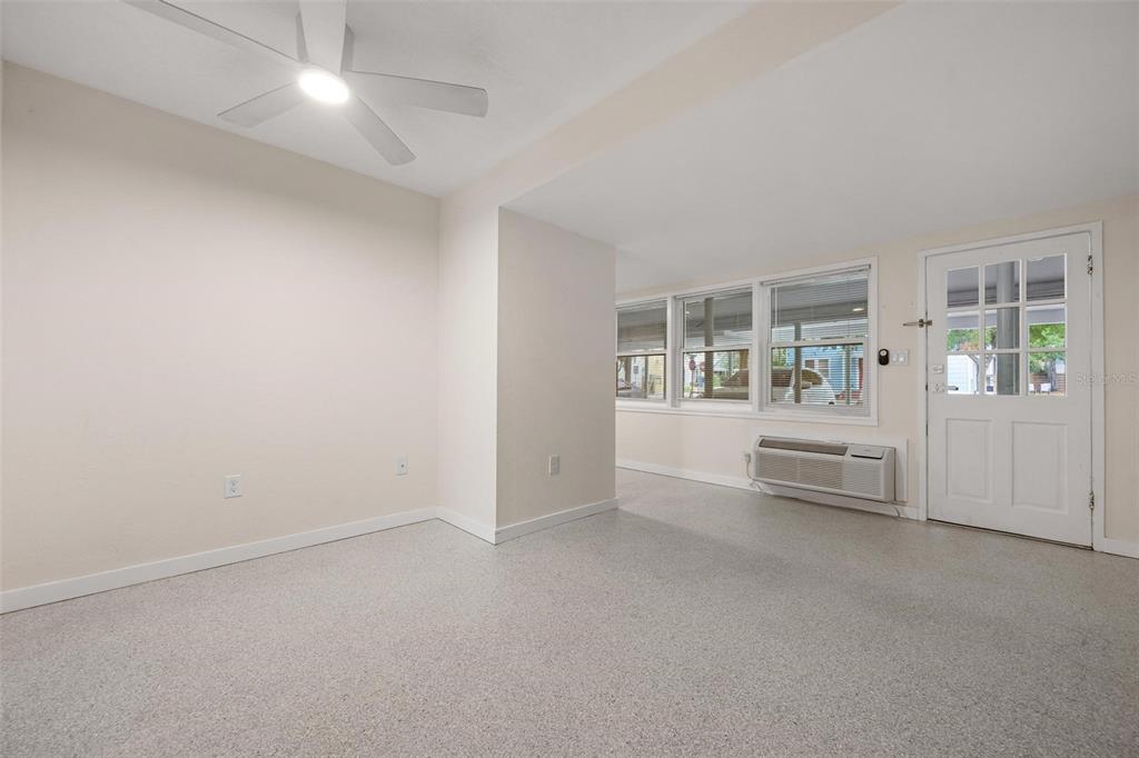 An interior room features light-colored walls, a ceiling fan, a windowed wall, and a door — 308 OHIO PLACE UNIT 2, SARASOTA, FL