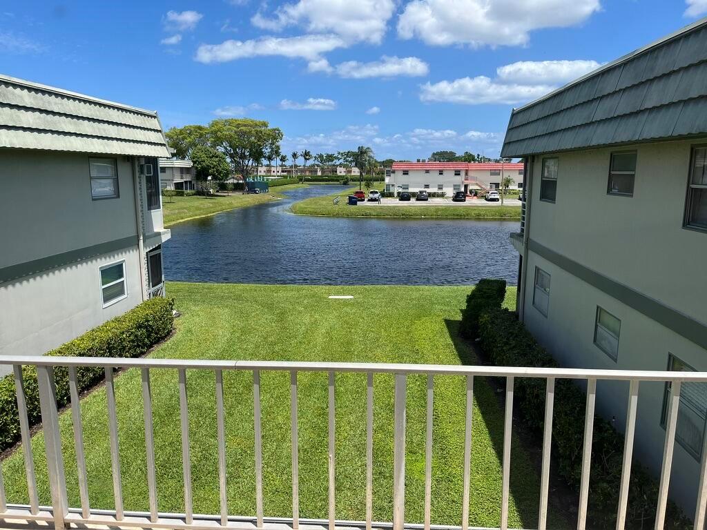 A view from a balcony overlooking a grassy lawn and a small lake between buildings — 716 Monaco Court # 716, Delray Beach FL 33446, DELRAY BEACH, FL
