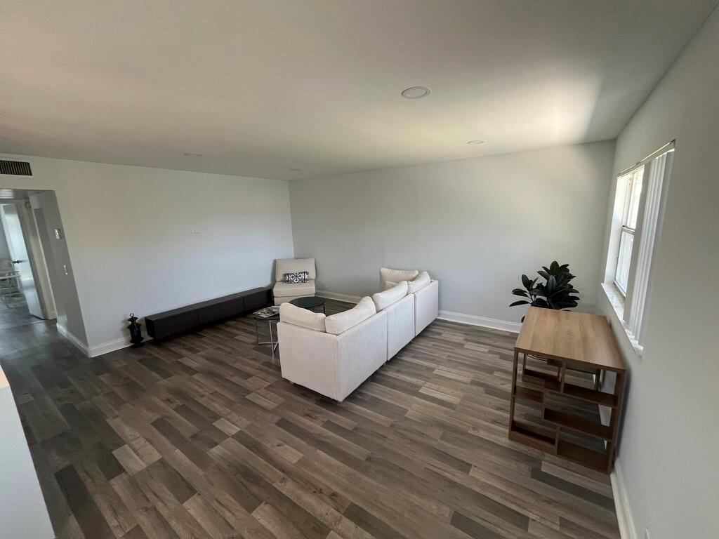 A living room features light gray walls, wood-look flooring, a white sectional sofa, and a console — 716 Monaco Court # 716, Delray Beach FL 33446, DELRAY BEACH, FL