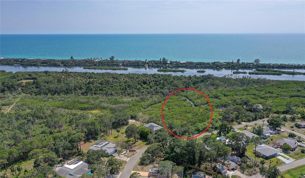 An aerial view shows a wooded lot circled in red near a body of water — 0 LEMON BAY DRIVE, VENICE, FL