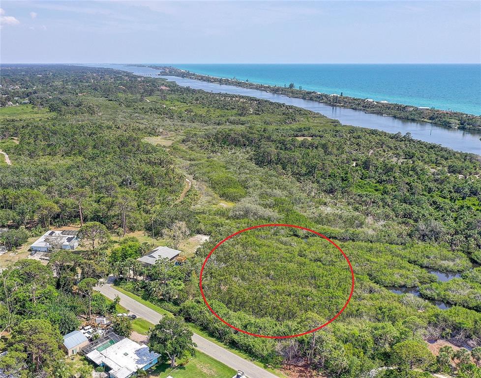 An aerial view shows a wooded lot circled in red near a coastal waterway — 0 LEMON BAY DRIVE, VENICE, FL
