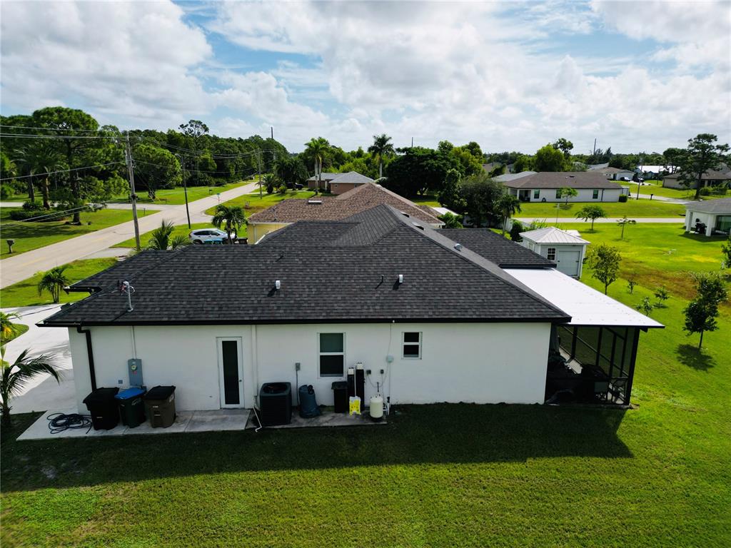 An aerial view of the back of a white house with a dark shingled roof — 528 JACARANDA PARKWAY E, CAPE CORAL, FL