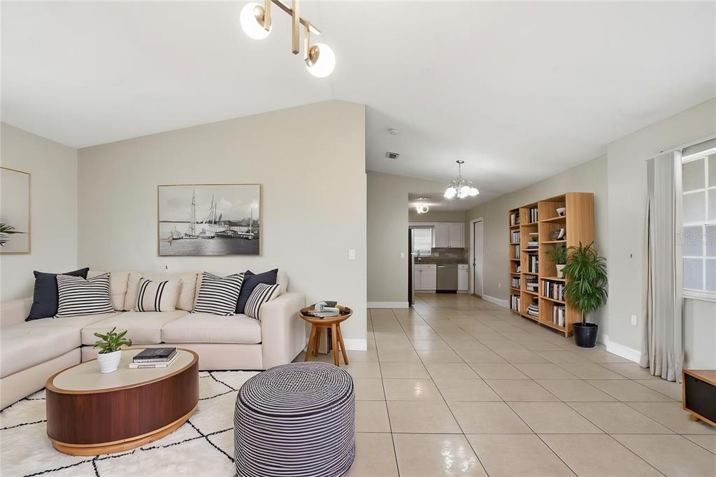 A living room with tile floors, a sectional sofa, and an open view to the kitchen — 2762 MYAKKA DRIVE, ORLANDO, FL