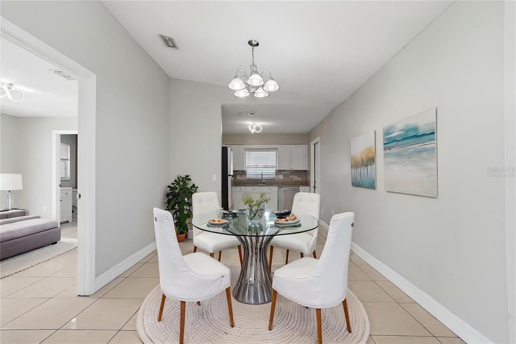 A dining area features a glass-topped table, four white chairs, and a round rug — 2762 MYAKKA DRIVE, ORLANDO, FL