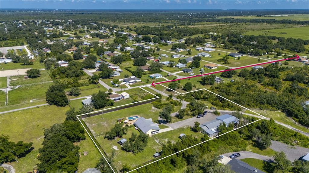 An aerial view shows a residential property with two buildings, a pool, and surrounding land — 30941 TURKEY OAK ROAD, PUNTA GORDA, FL