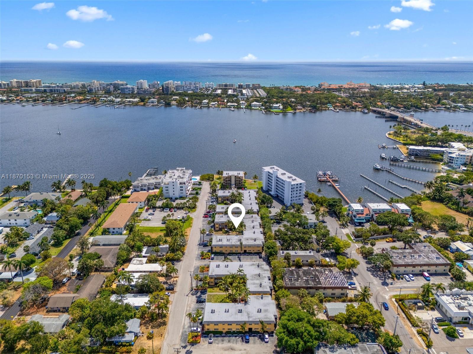 An aerial view shows a multi-story apartment complex with parking lots near a large bay — 200 Croton Ave # 111, Lantana FL 33462, LANTANA, FL