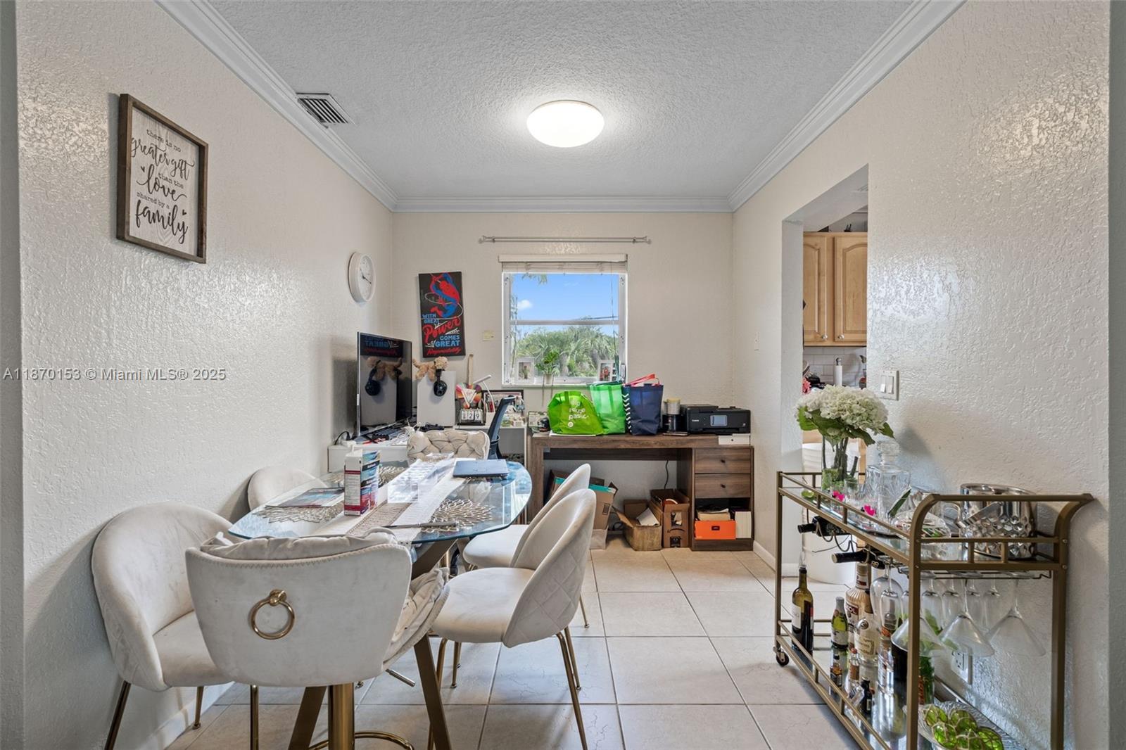 A dining room features a glass table, upholstered chairs, a bar cart, and a desk — 200 Croton Ave # 111, Lantana FL 33462, LANTANA, FL